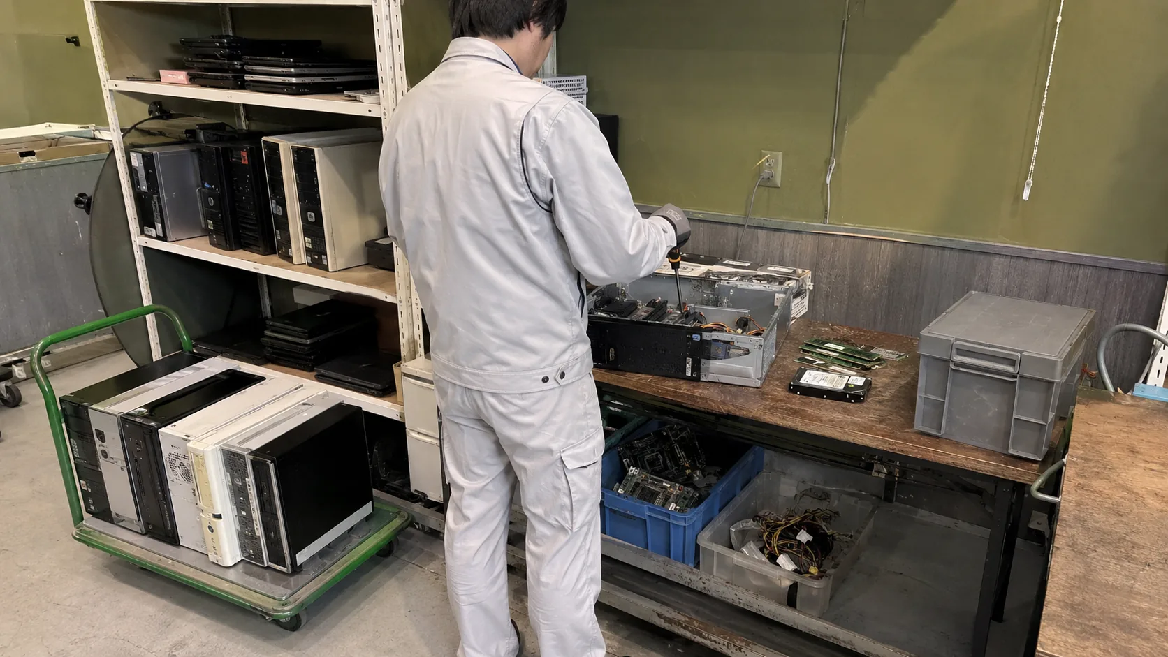 回収したパソコンを分解し、基板・HDD・電源・筐体を部材ごとに取り外す作業